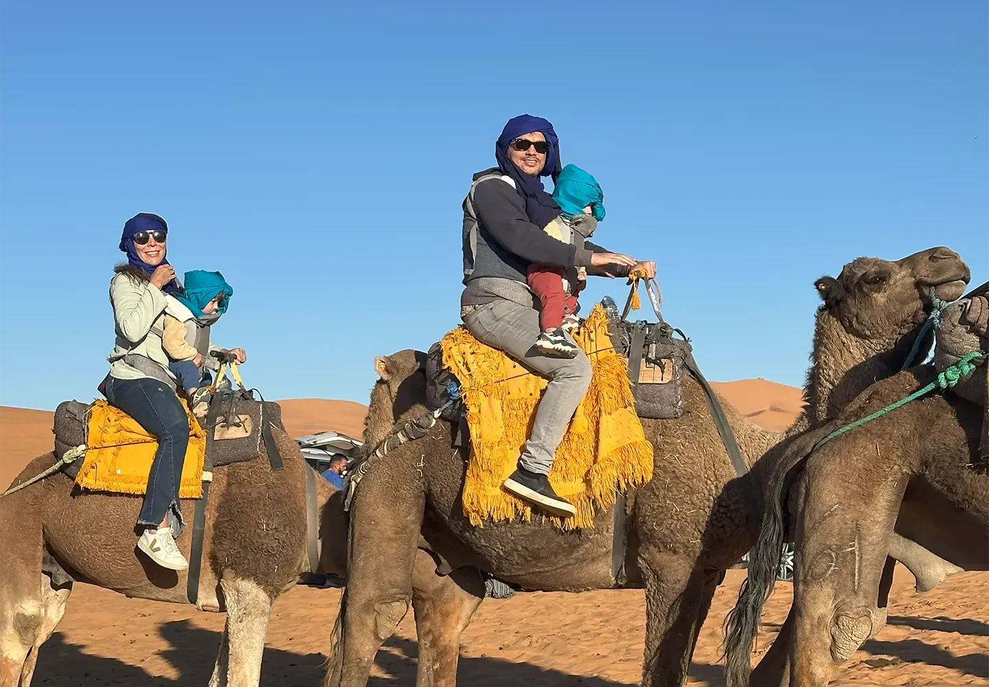 a family with two children in morocco family tours camel ride sahara desert merzouga