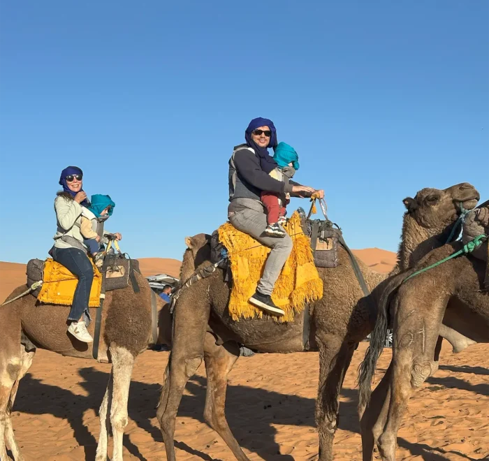 morocco-family-tour-camel-ride-sahara-desert-merzouga a family with two children in morocco family tours camel ride sahara desert merzouga